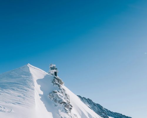 Stunning view of the Jungfraujoch observatory (Sphinx) perched on snow-covered peaks at the Top of Europe in Switzerland — featured on Zurich Private Tours.